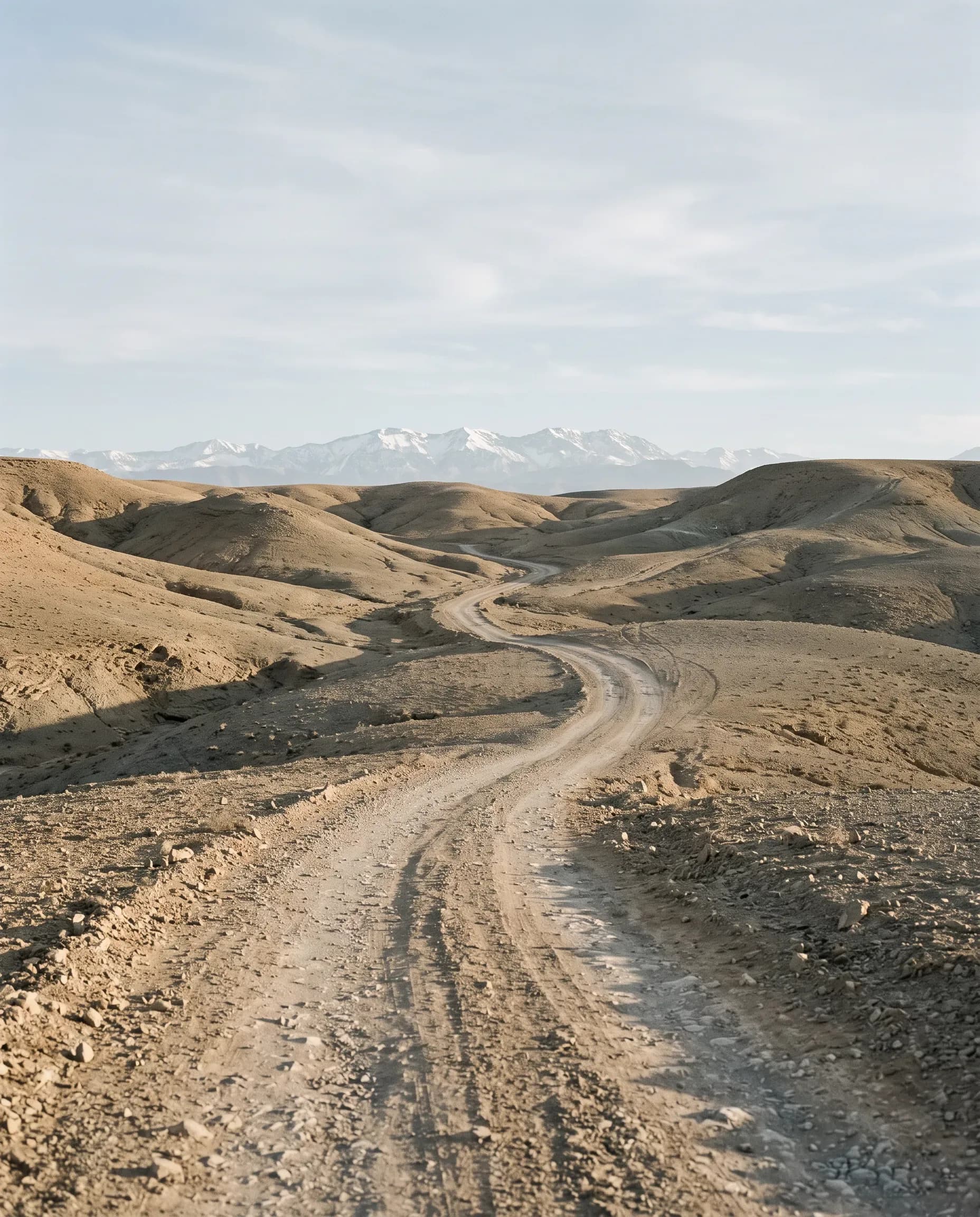 Piste caillouteuse du désert d'Agafay à 30 km de Marrakech, collines de pierre à l'horizon